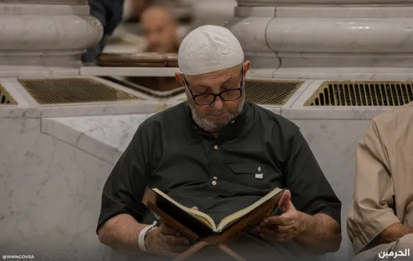 معتمر يجلس داخل المسجد النبوي يقرأ القرآن - الصورة من حساب الهيئة العامة للعناية بشؤون الحرمين المسجد النبوي على منصة إكس