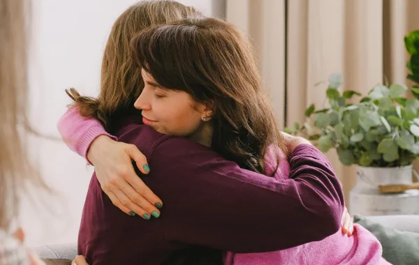 شابة تحتضن صديقتها تشكرها ممتنة لما فعلته معها