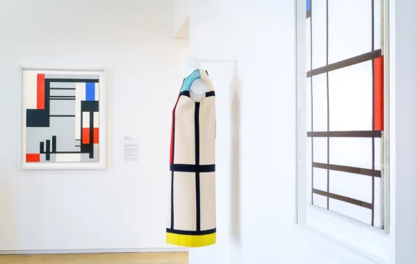 معرض خاص بأعمال إيف سان لوران بعد مرور 60 عاماً على أول عرض له، في متحف Yves Saint Laurent Museum، في باريس، وفي الخلفية لوحة Composition in red, blue and white للرسام بيت موندريان Piet Mondrian، من عام 1937 (مصدر الصورة: Philippe Petit /Paris Match via Getty Images)