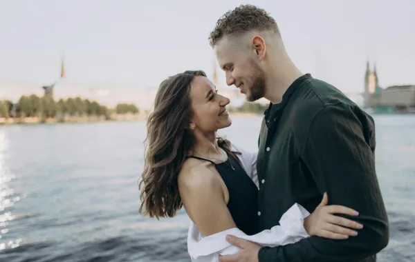 زوج يحتضن كتف زوجته ويمسك يدها وهي يبدو عليها الشعور بالسعادة والأمان