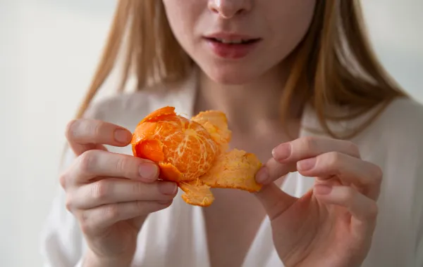 سيدة تتناول اليوسفي- المصدر freepik