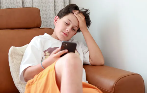 صورة مراهق مدمن على الهاتف