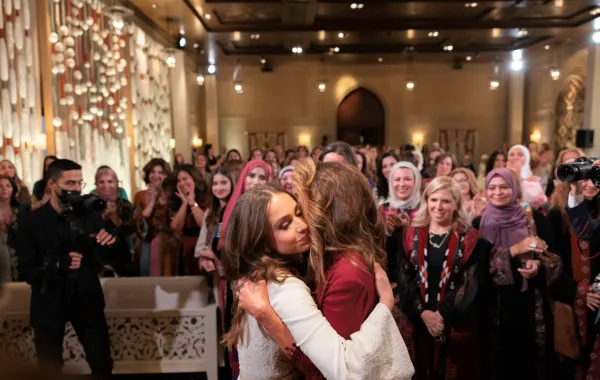 الملكة رانيا تعانق ابنتها الأميرة إيمان بنت عبد الله في حفل الحناء (Queen Rania hugging her daughter Princess Iman bint Abdullah). مصدر الصورة: Office of Her Majesty Queen Rania Al Abdullah / AFP