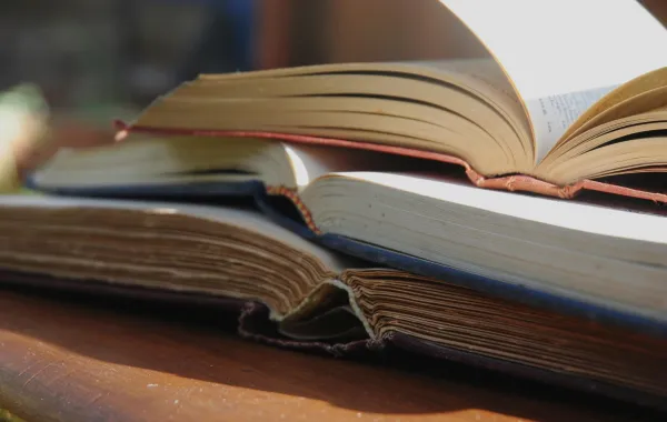 مجموعة من الكتب المفتوحة موضوعة على الطاولة 