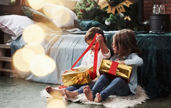 صورة لطفلين يفتحان الهدايا