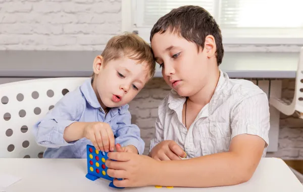 صورة طفلين يحاولان حل مشكلة لعبة