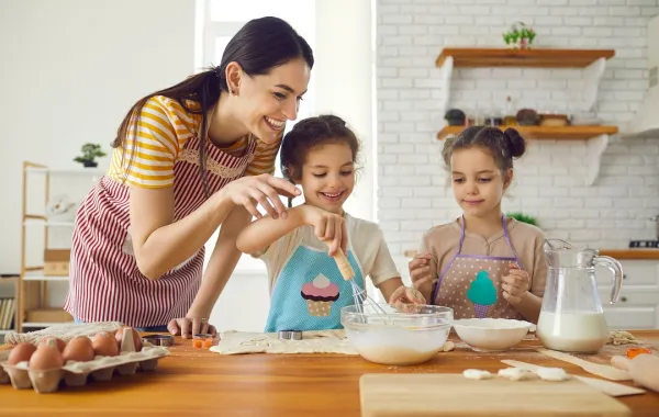 صورة لأم وطفلتيها بالمطبخ