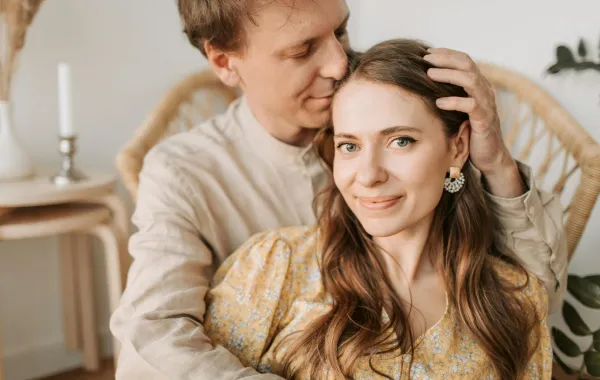 زوج يحتضن ويدعم زوجته ويضع يده على رأسها ويقبلها