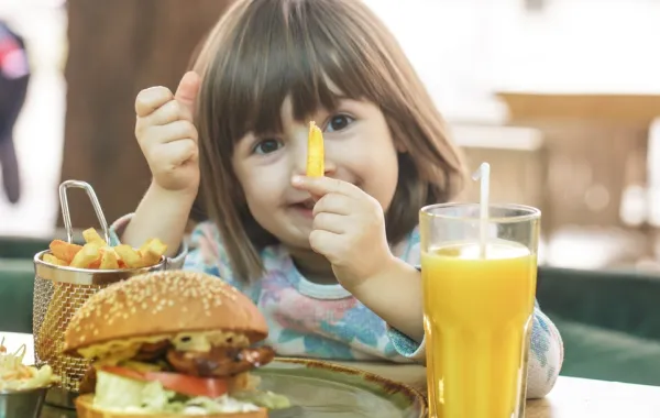 صورة لطفلة تأكل وجبة من البطاطس