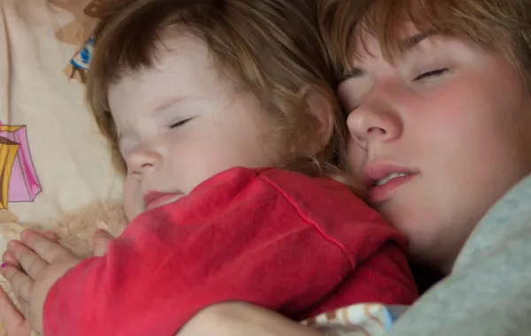 صورة طفل ينام بجانب أمه