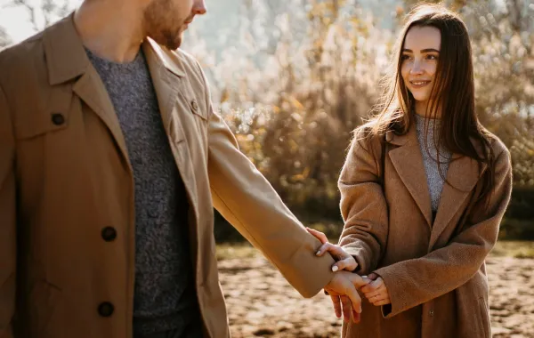 زوجة محبة تنظر لزوجها بشوق وتمسك بيده بدفء