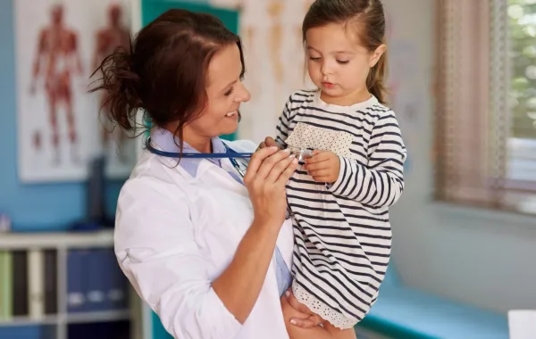 صورة طبيبة تداعب الطفلة