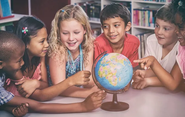 صورة أطفال يجتمعون حول الكرة الأرضية