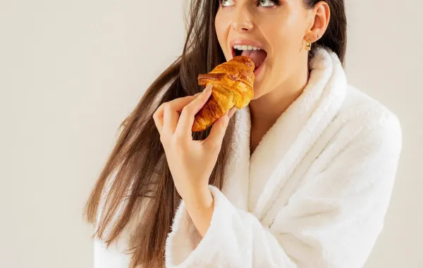 امرأة تتناول الكرواسان بشراهة- المصدر:Pexels-teja-klinar