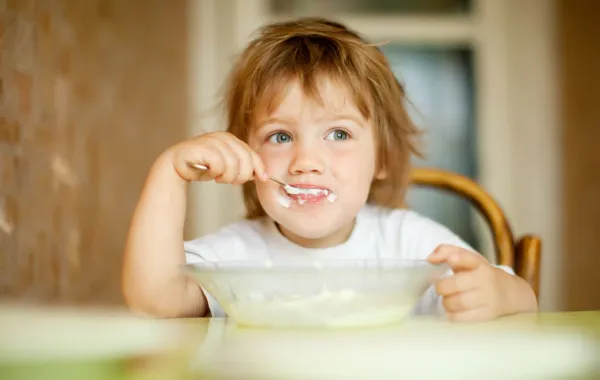 صورة لطفل يأكل الزبادي باستمتاع