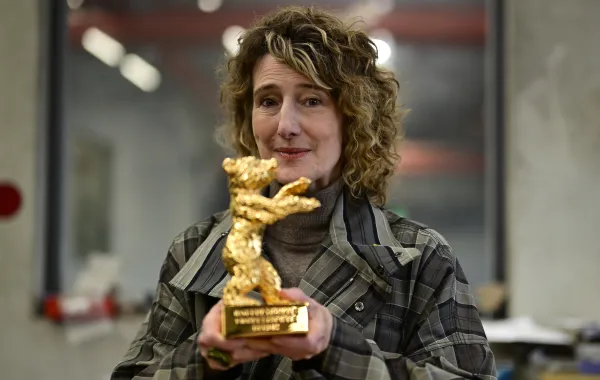 مديرة مهرجان برلين السينمائي الدولي، تريشيا تاتل، وهي تحمل جائزة «الدب الذهبي» - مصدر الصورة  AFP