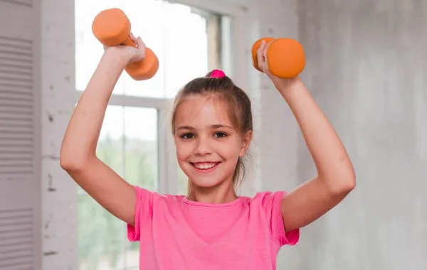 صورة لطفلة تحمل أثقالا تناسب عمرها