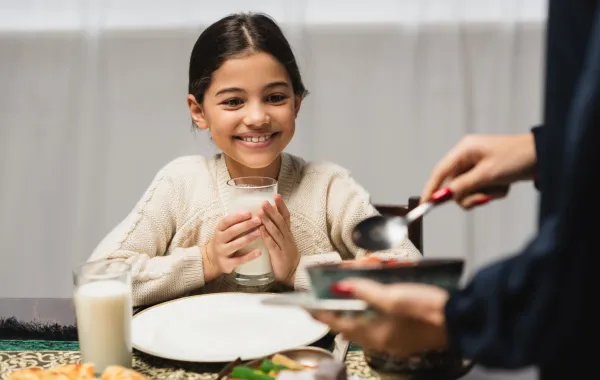 صورة أم تقدم الطعام لطفلتها