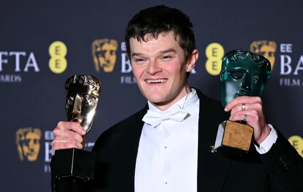 روبرت أرامايو Robert Aramayo مع جائزتيّ البافتا - مصدر الصورة : JUSTIN TALLIS / AFP