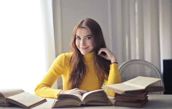 شابة تقرأ عدداً من الكتب في إدارة الأعمال والقيادة 