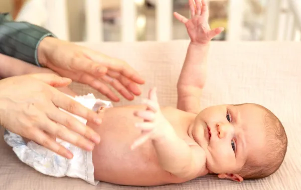 صورة لأم تغير حفاض مولودها