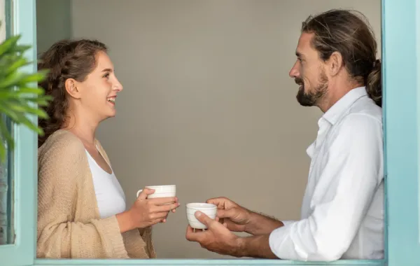 زوجان يتناولان فنجانان من الشاي ويتحدثان بهدوء عن حياتهما الزوجية