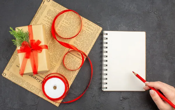  شابة ستكتب كلمات إهداء رقيقة على كارت لتضعه على الهدية   