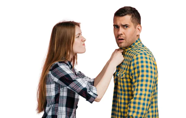 زوجة تعاتب زوجها وتمسكه من طرف قميصه وهو ينظر للأمام باستياء ساخر  
