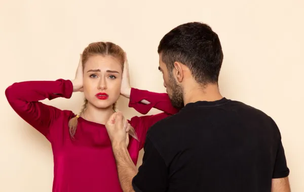 زوجة ترفض علاقتها السامة مع زوجها فتضع يديها على أذنيها كي لا تسمع كلامه السام   