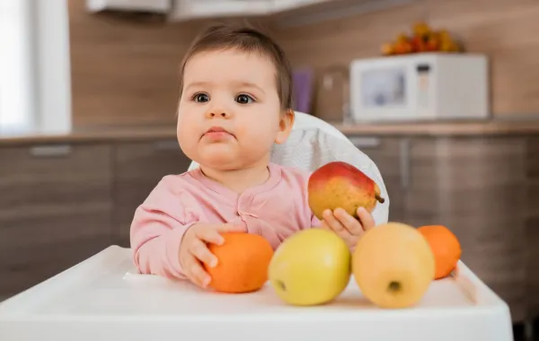 صورة رضيع يمسك بالفاكهة