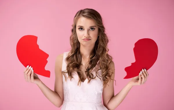 فتاة تمسك قلباً مكسوراً علامة على انفصالها عن خطيبها   