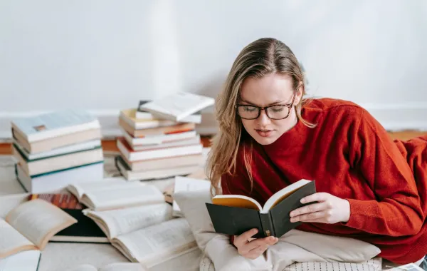 شابة تقرأ مجموعة من كتب السيرة الذاتية 