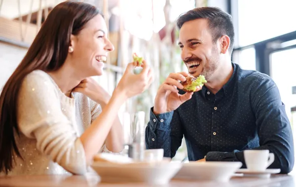 زوجان يتناولان الطعام سوياً بسعادة