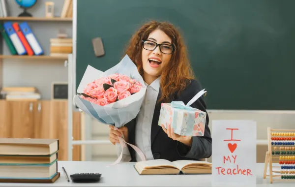 معلمة تحمل باقة من الزهور وهدية أحضرتها لها الأمهات لشكرها   