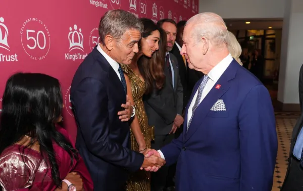 الملك تشارلز الثالث يصافح جورج كلوني في قاعة ألبرت الملكية بلندن (King Charles III shakes hands with George Clooney at the Royal Albert Hall in London). مصدر الصورة: Aaron Chown / POOL / AFP