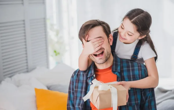 صورة لطفلة تقدم هدية لأبيها