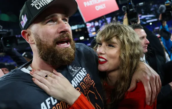 ترافيس كيلسي مع تايلور سويفت في ملعب إم آند تي بانك في بالتيمور، ميريلاند (Travis Kelce with Taylor Swift at M&T Bank Stadium in Baltimore, Maryland). مصدر الصورة: Patrick Smith/Getty Images/AFP