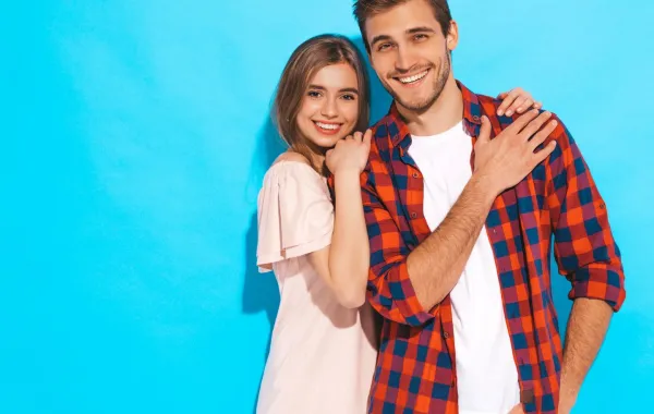 زوجة شابة مبتسمة تستند تحتضن كتف زوجها بسعادة