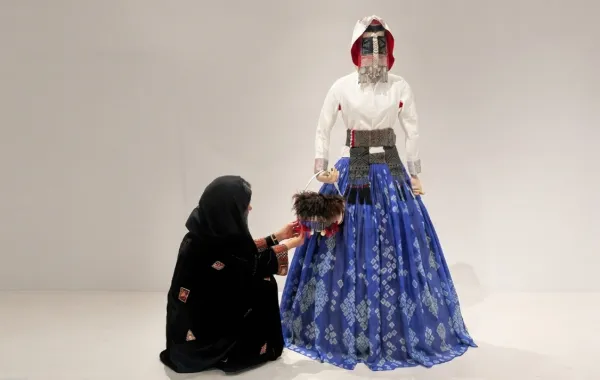 المصممة رند السيف مع تصميمها سعودية