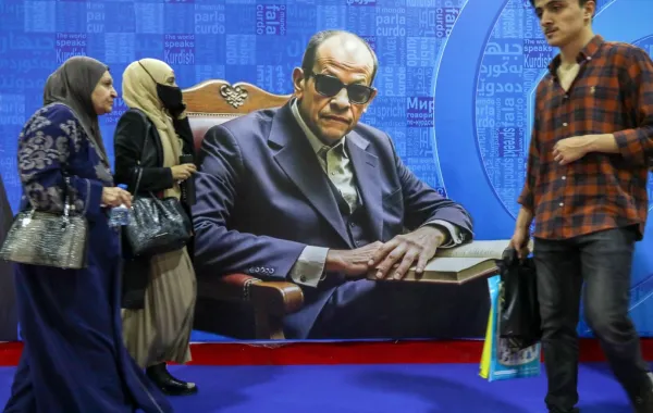 زوار يمرون بجوار ملصق يصور الكاتب المصري الراحل نجيب محفوظ