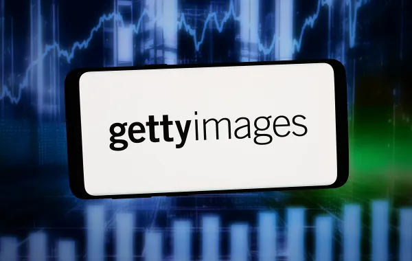 شعار شركة Getty Images Holdings Inc الأمريكية على هاتف ذكي، أمام خلفية تجريدية معروضة على شاشة حاسوب: المصدر: Timon Schneider / SOPA Images / LightRocket عبر Getty Images.
