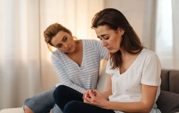 شابة تربت على كتف صديقتها وتواسيها بعد أن فقدت وظيفتها