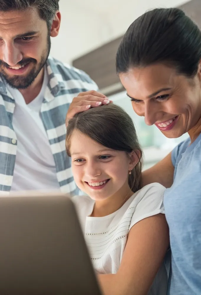 صورة لطفلة ووالديها أمام الجهاز