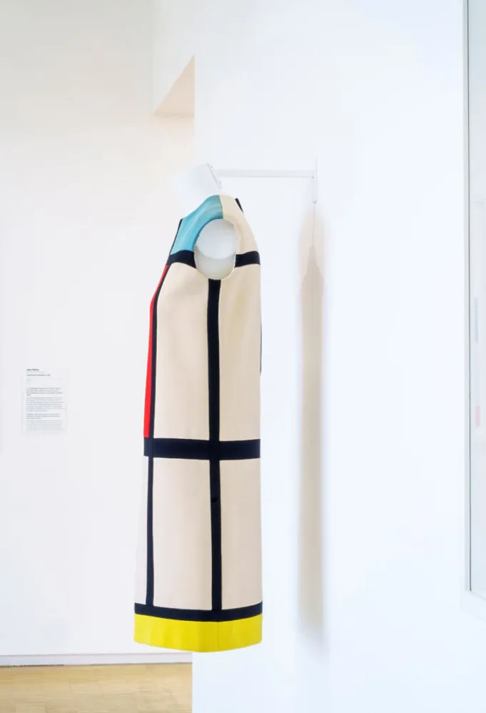 معرض خاص بأعمال إيف سان لوران بعد مرور 60 عاماً على أول عرض له، في متحف Yves Saint Laurent Museum، في باريس، وفي الخلفية لوحة Composition in red, blue and white للرسام بيت موندريان Piet Mondrian، من عام 1937 (مصدر الصورة: Philippe Petit /Paris Match via Getty Images)