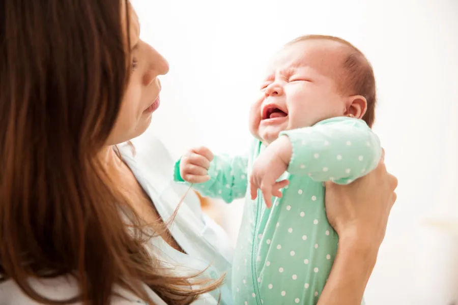 صورة لأم تحمل رضيعها الباكي