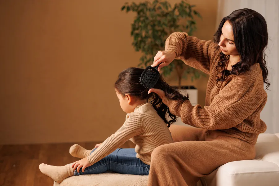 صورة أم تمشط شعر ابنتها