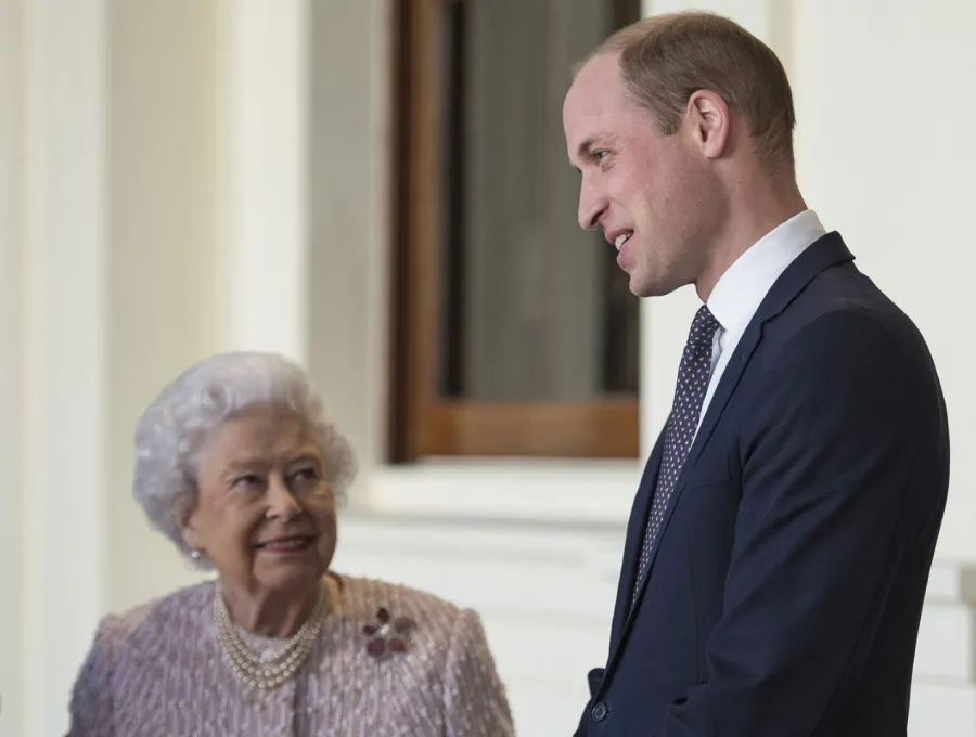 الملكة إليزابيث الثانية مع حفيدها الأمير ويليام بقصر باكنغهام في وسط لندن (Queen Elizabeth II with her grandson Prince William outside the Grand Entrance of Buckingham Palace in central London). مصدر الصورة: Victoria Jones / POOL / AFP
