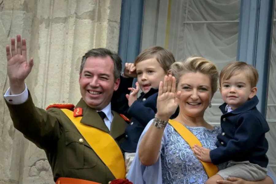الدوق الأكبر غيوم والدوقة ستيفاني يحملان ابنيهما تشارلز وفرانسوا من شرفة القصر الدوقي الكبير (Grand Duke Guillaume and Duchess Stephanie hold their sons Charles and Francois from the balcony of the Grand Ducal Palace). مصدر الصورة: NICOLAS TUCAT / AFP