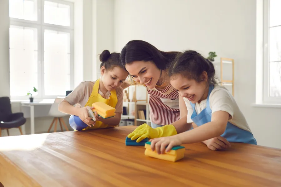 أم وابنتاها الصغيرتان تقومان بأعمال المنزل
