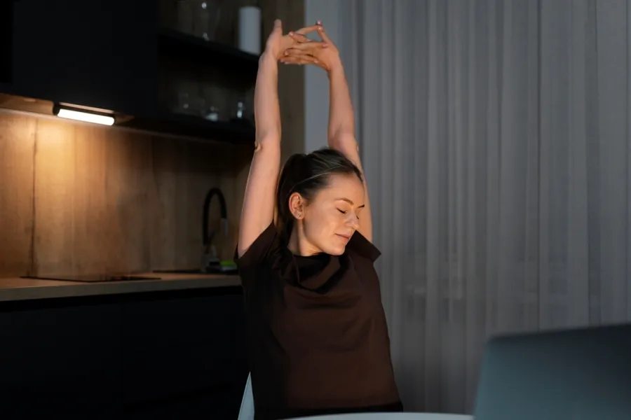 سيدة تقوم بحركات تمدّد بسيطة قبل النوم  Image By Freepik